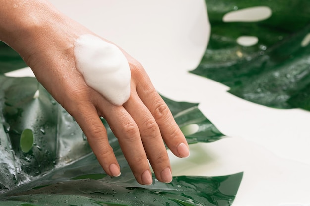 Primer plano de una mano femenina con una espuma limpiadora