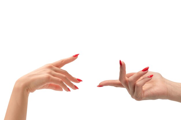 Primer plano de una mano femenina con piel pálida y uñas rojas apuntando o tocando aislado sobre un fondo blanco.