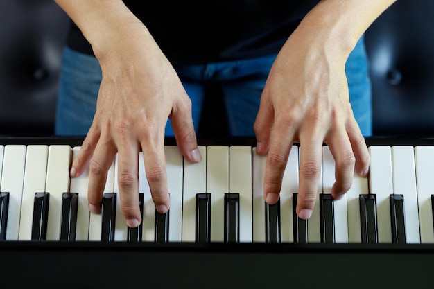 El primer plano de la mano gente hombre músico tocando el teclado del piano con teclas de enfoque selectivo se puede utilizar como fondox9