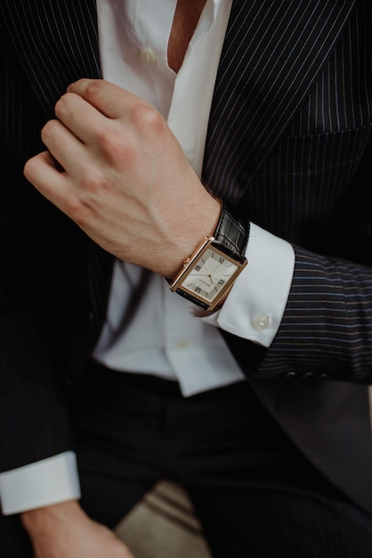 Primer plano de la mano de un hombre elegante con un traje y un reloj de pulsera de moda
