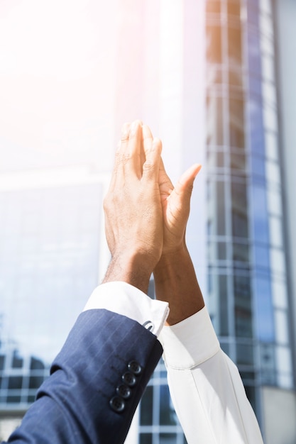 Foto primer plano de la mano del hombre de negocios y de la empresaria que da el alto cinco