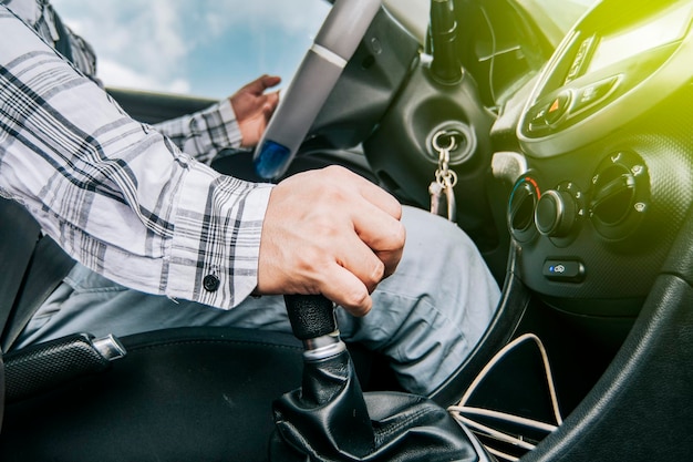 Primer plano de la mano de un hombre en la palanca de cambios de un automóvil concepto de velocidad y palanca de cambios primer plano de las manos acelerando en la palanca de cambios