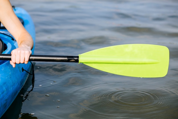 Foto primer plano de la mano de un hombre remando un kayak