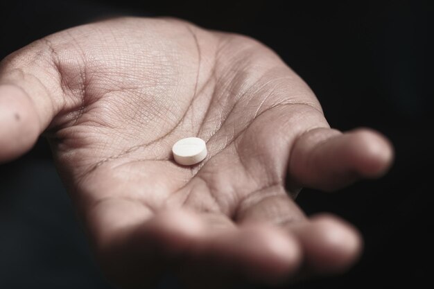 Primer plano de la mano del hombre sosteniendo pastillas con espacio de copia