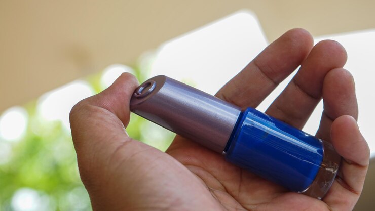 Foto primer plano de una mano humana sosteniendo pintura para uñas