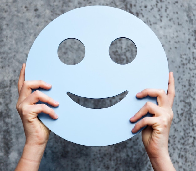 Primer plano de una mano humana sosteniendo un smiley