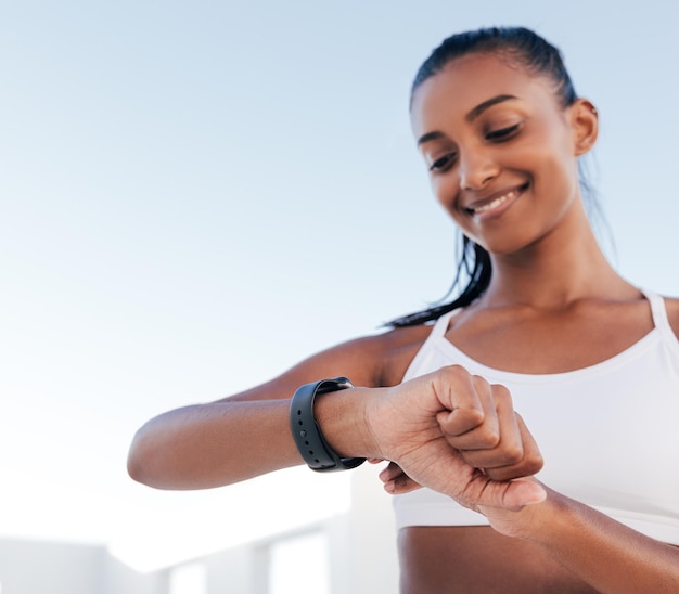 Primer plano de una mano de una joven delgada ajustando su reloj inteligente antes de un entrenamientox9