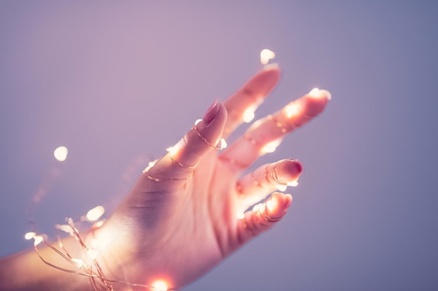 Foto primer plano de la mano en la luz iluminada contra el cielo