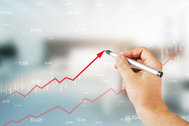 Primer plano de la mano masculina dibujo creciente flecha roja del gráfico de negocios en el fondo interior de la oficina borrosa Concepto de ganancias y aumento de finanzas