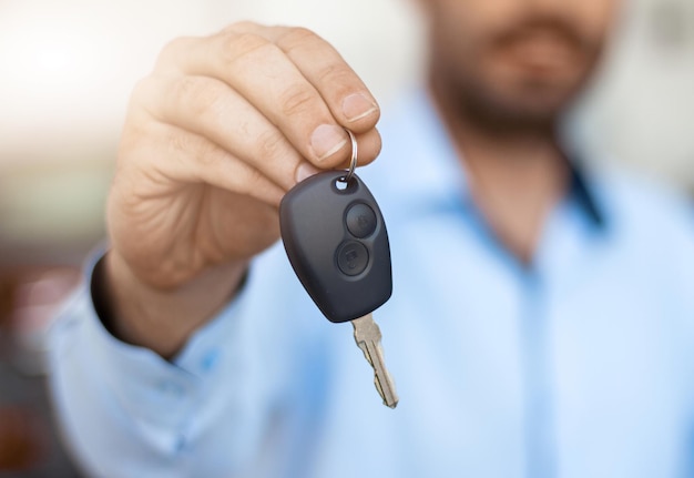 Primer plano de la mano masculina sosteniendo la llave del coche Concepto de compra y alquiler de automóviles