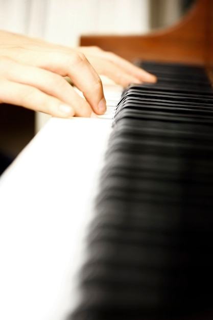 Un primer plano de una mano masculina tocando el piano