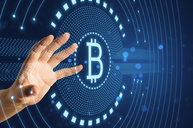 Primer plano de la mano masculina usando un holograma de bitcoin redondo y brillante creativo en fondo azul Concepto de criptografía y finanzas