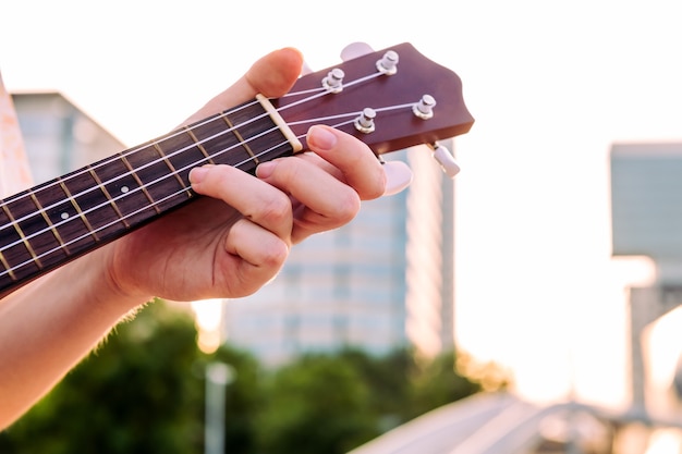 Foto primer plano de la mano de la mujer en el cuello de un ukelele