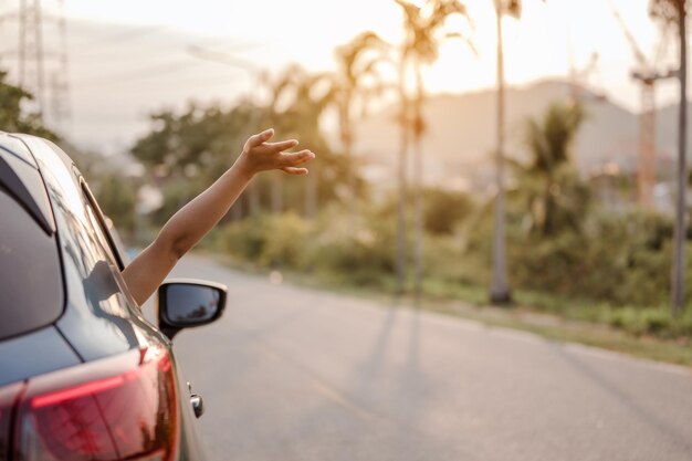 Foto primer plano de la mano de una mujer fuera de la ventana del coche