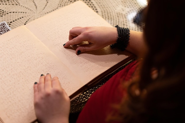 Un primer plano de la mano de una mujer leyendo un libro en braille