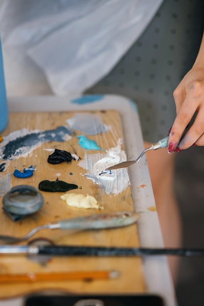 Primer plano de la mano de la mujer mezclar pinturas en la paleta