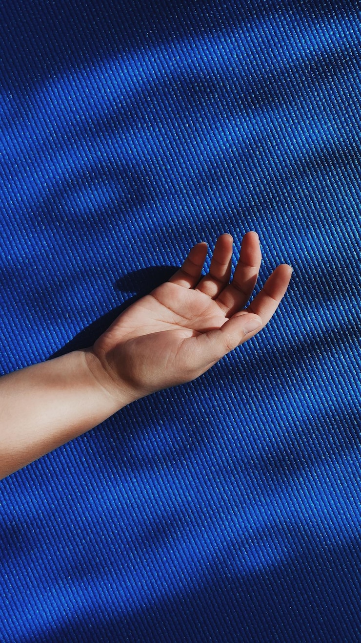 Foto primer plano de la mano de una mujer en la pared púrpura