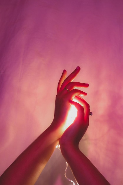 Primer plano de la mano de la mujer en la pared roja