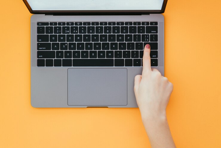 Foto primer plano de la mano de la mujer presionando el botón enter en el teclado de la computadora portátil