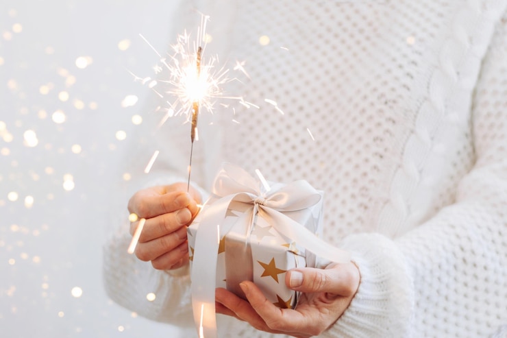 Foto primer plano de la mano de una mujer sosteniendo un árbol de navidad iluminado