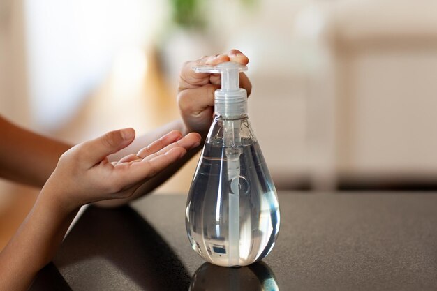 Primer plano de la mano de la mujer sosteniendo una botella de vidrio