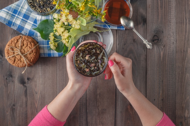 Primer plano de la mano de una mujer sosteniendo una taza de té de miel con miel