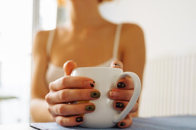 Foto primer plano de la mano de una mujer sosteniendo una taza