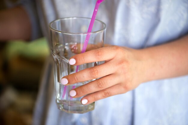 Primer plano de la mano de una mujer sosteniendo un vaso de agua concepto de estilo de vida saludable