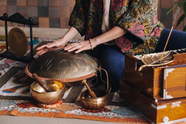 Primer plano de la mano de una mujer tocando un instrumento musical moderno, el tambor de lengüeta de Orión