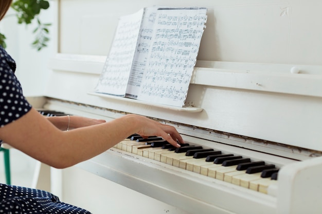 Foto primer plano de la mano de una mujer tocando el piano