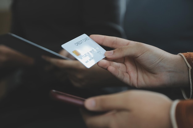 Primer plano de la mano de la mujer usando tarjeta de crédito y computadora portátil para pagos y compras en línea Pagos de compras en línea banca digital Concepto de comercio electrónico