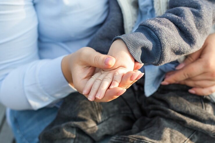 Foto primer plano de la mano del niño en manos de la madre. concepto de niños con discapacidad.