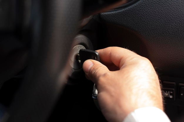 Primer plano de la mano de una persona insertando la llave para arrancar el coche