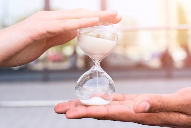 Foto primer plano de la mano de la persona con reloj de arena