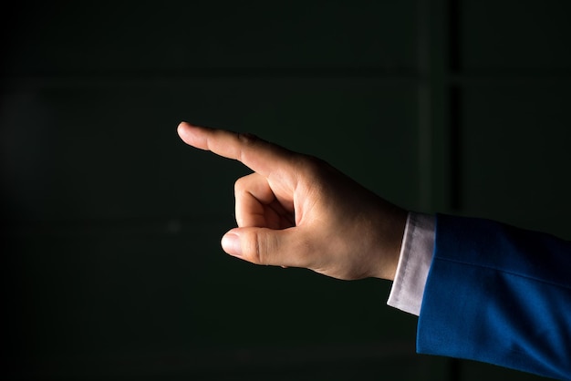 Foto primer plano de la mano de una persona sosteniendo papel contra un fondo negro