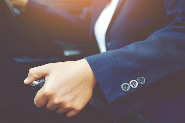 Primer plano de la mano de la persona tirando de la palanca del freno de mano en el coche Por seguridad mientras se estaciona