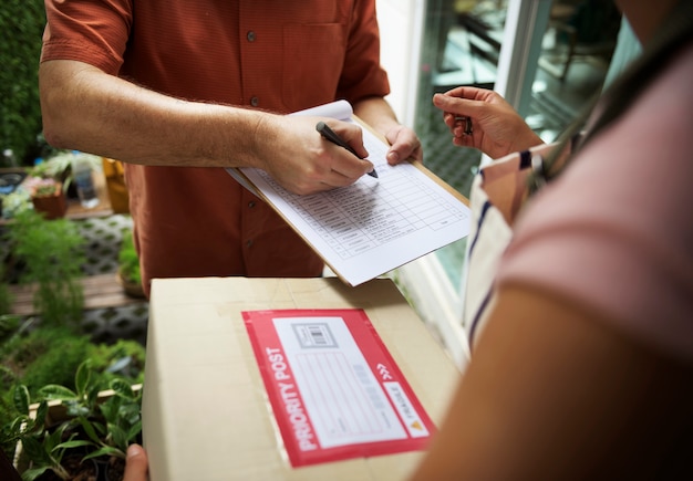 Primer plano de la mano que firma en el papel de entrega