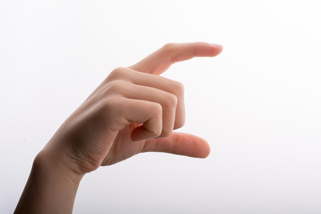 Primer plano de la mano que sostiene el dedo contra un fondo blanco