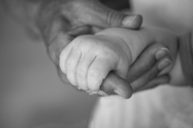 Foto primer plano de la mano que sostiene la mano del bebé