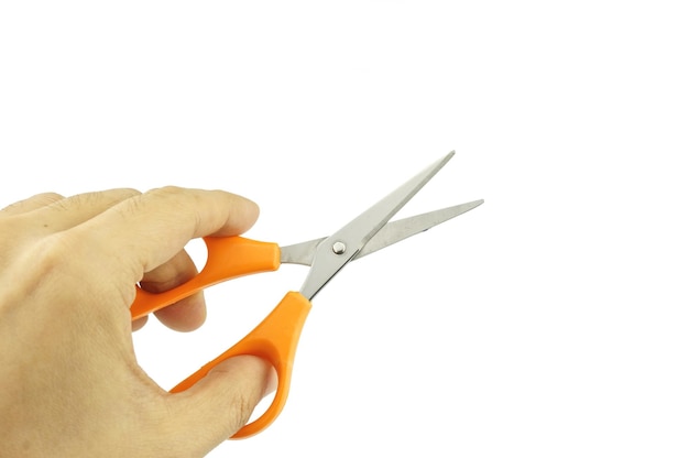 Primer plano de la mano que sostiene las tijeras contra un fondo blanco