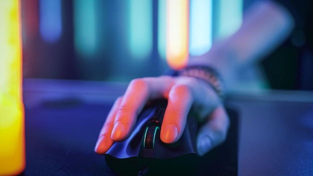 Primer plano de la mano que usa el ratón de la computadora Luces de neón retro frescas Navegando por Internet o jugando juegos en línea