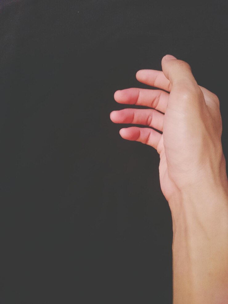 Foto primer plano de la mano recortada contra un fondo negro