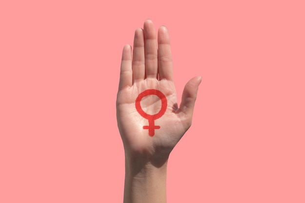 Foto primer plano de la mano recortada con el signo contra un fondo rosa