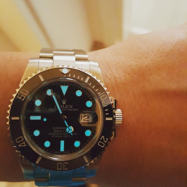 Primer plano de una mano recortada usando un reloj de lujo