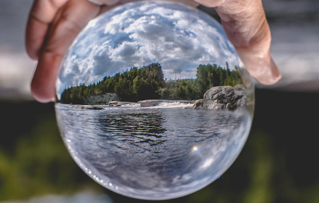 Foto primer plano de una mano sosteniendo agua contra el cielo