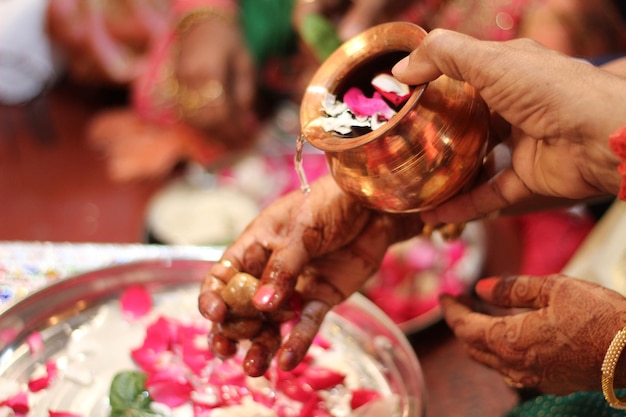 Foto primer plano de la mano sosteniendo el artículo de la boda india en el recipiente