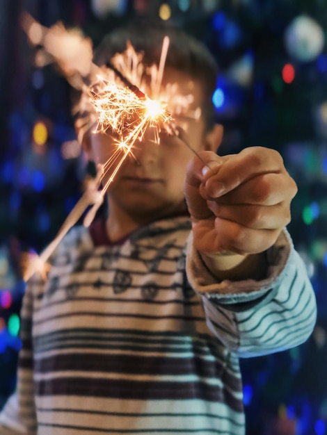 Foto primer plano de la mano sosteniendo una bengala por la noche