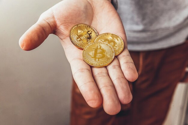 Primer plano de una mano sosteniendo bitcoin