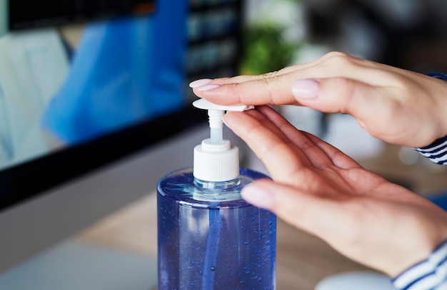 Foto primer plano de la mano sosteniendo la botella contra un fondo borroso