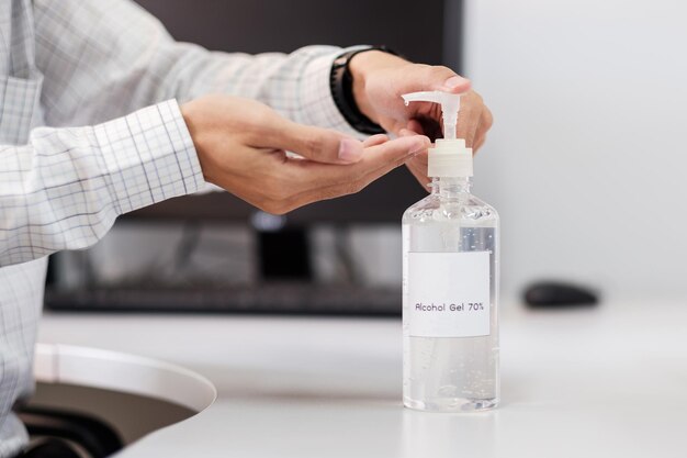 Foto primer plano de la mano sosteniendo una botella de vidrio